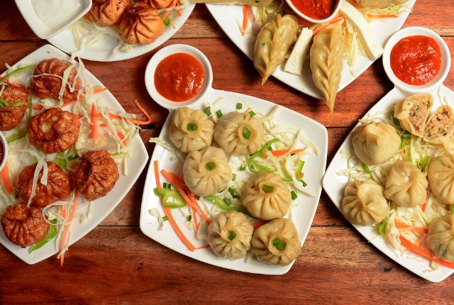 momos in white color plate with red chutney.