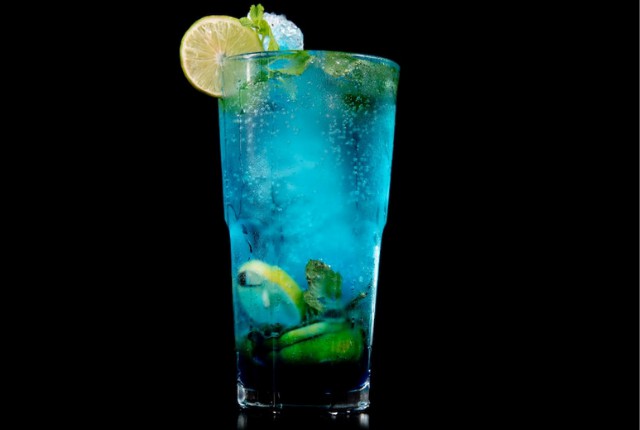 blue virgin mojito in glass with lemon slice.