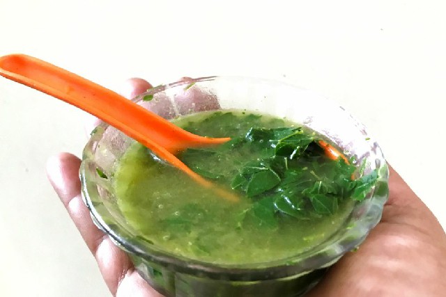 moringa leaves soup in bowl with spoon.