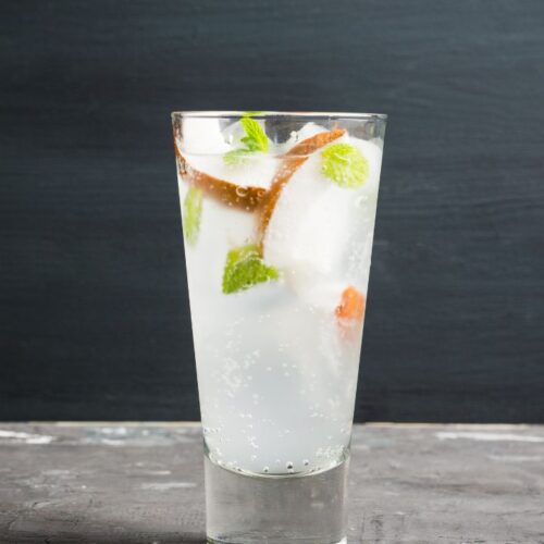 coconut mojito in glass with ice cubes and mint leaves.