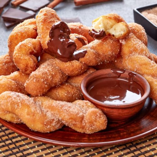 kkwabaegi or korean doughnuts in plate with dip bowl,