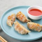 korean mandu in the plate with red chutney.