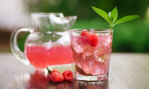 raspberry mojito in glass with ice cubes, mint leaves and raspberry.