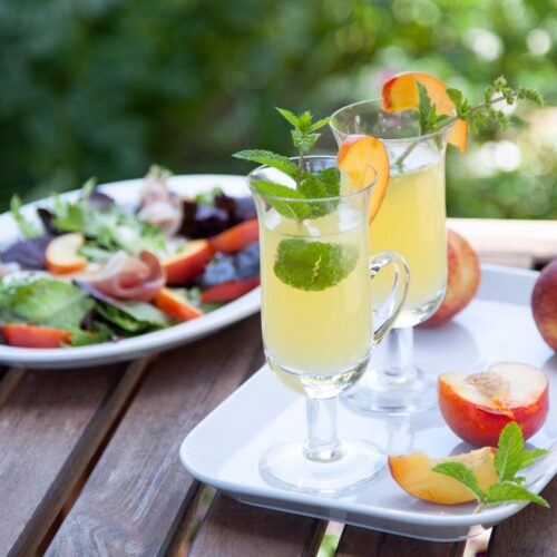 peach mojito in glass with mint leaves.