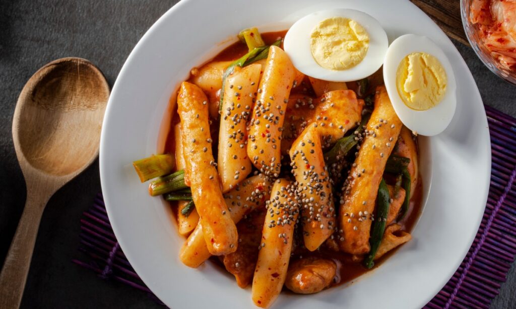 Tteokbokki or spicy rice cakes in white color bowl. Bowl on the tableware.