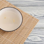 Sikhye or korean sweet rice drink in white color bowl which is on the tableware.