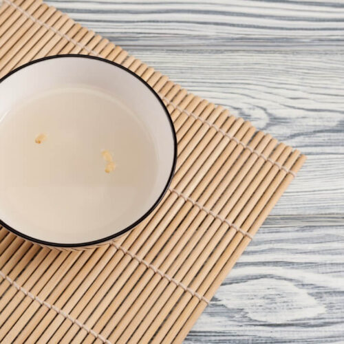 Sikhye or korean sweet rice drink in white color bowl which is on the tableware.
