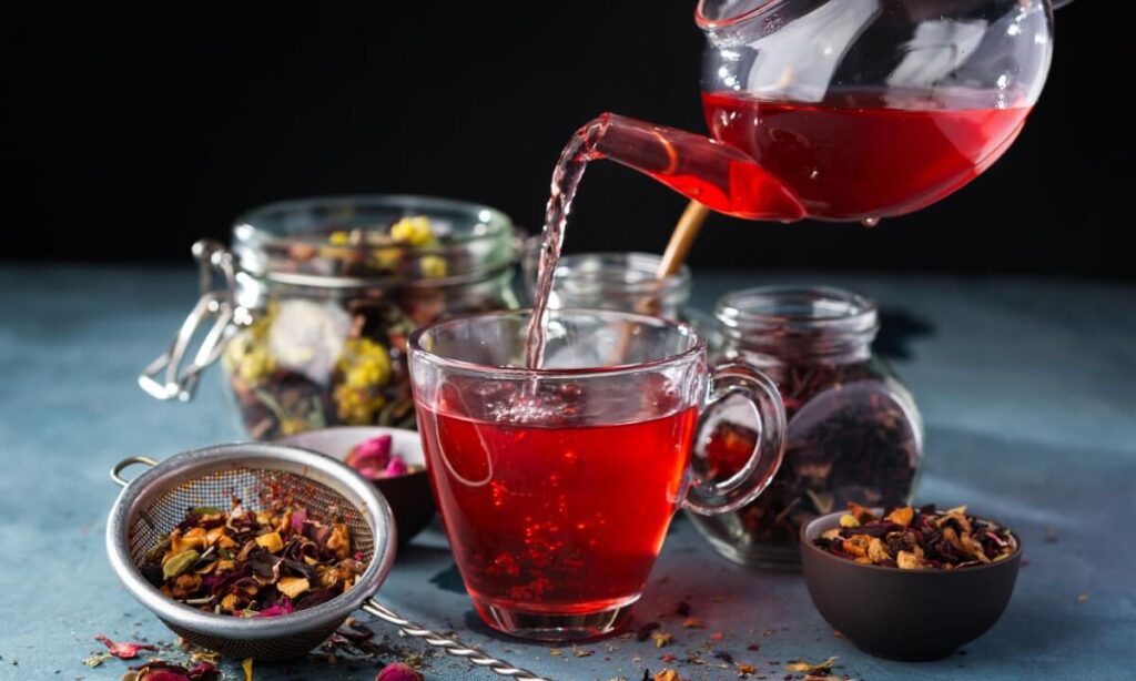 A Kashmiri Kahwa being poured into a glass cup.